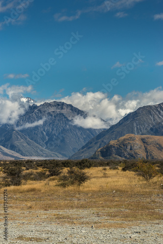 Middle Earth, New Zealand - March 14, 2017: Portrait of Snow capped High mountain range around Rock of Middle Earth under blue sky with white clouds. Set in a high desert mountainous scenery.