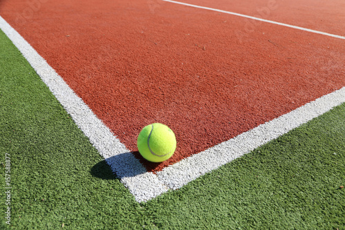 Tenniplatz mit Seitenlinien und gelbem Tennisball, Symbolbild