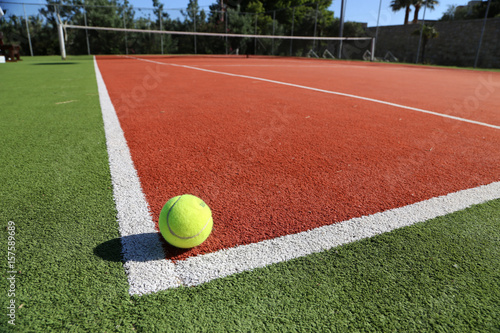 Gelber Tennisball liegt auf weißer Linie auf Spielfeld, Symbolbild Tennis © fotofox33