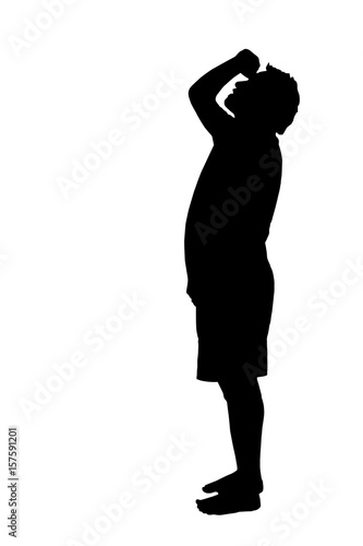 Side profile portrait silhouette of barefoot man looking upward at high object