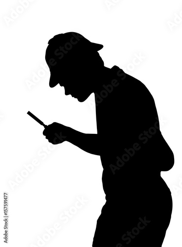 Silhouette of teenage boy investigating with a magnifying glass and Sherlock hat