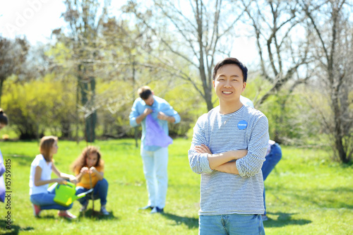 Young Asian volunteer with team outdoors