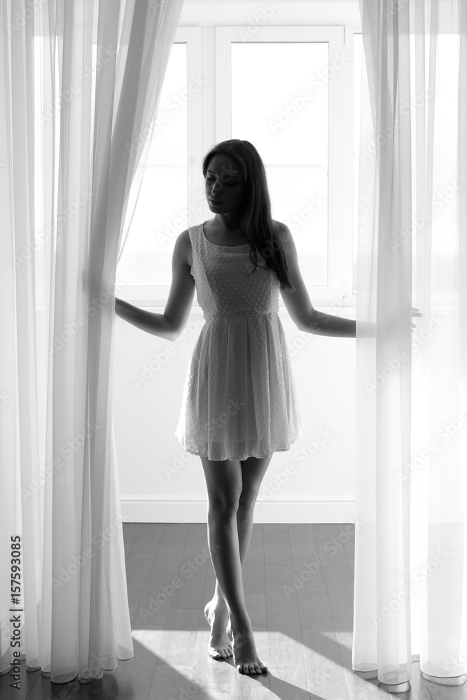 Woman in white dress on the morning on the balcony