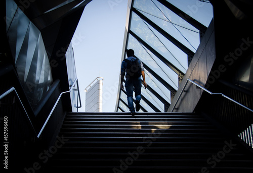 Man walking up steps in futuristic tunnel