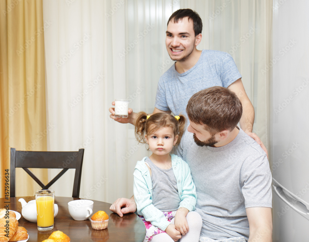 Male gay couple with daughter having breakfast in kitchen Male gay couple with daughter having breakfast in kitchen