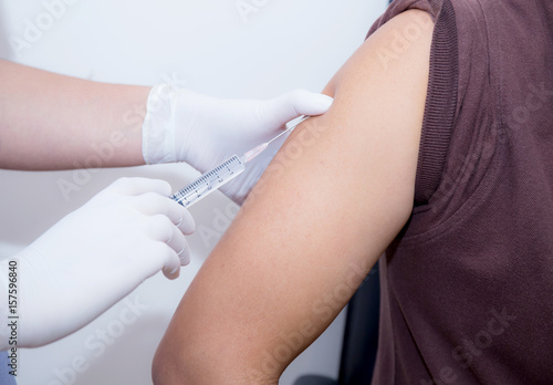 Close-up Of Doctor Injecting Patient With Syringe To Collect Blood