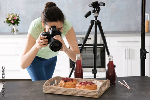 Young woman photographing food in photo studio photo