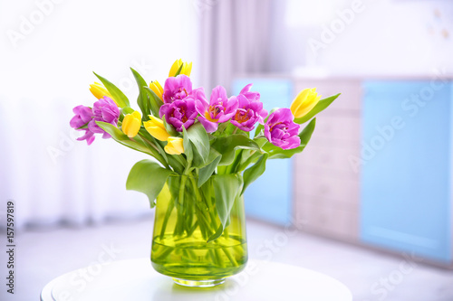 Glass vase with bouquet of beautiful tulips on table