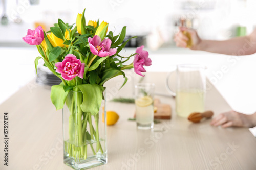Glass vase with bouquet of beautiful tulips on table
