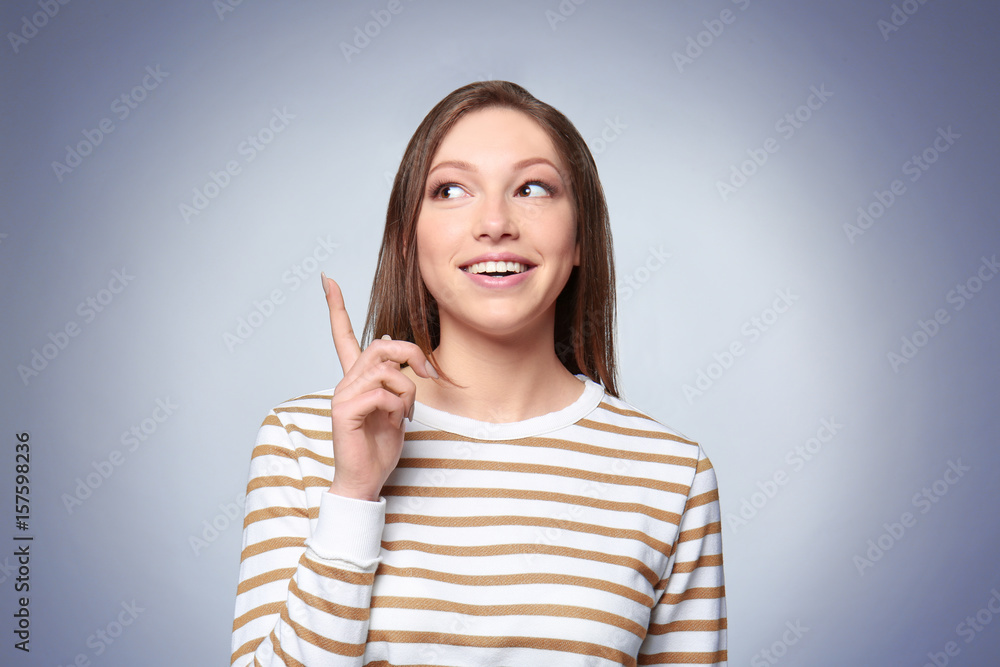 Beautiful quick-witted young woman on gray background Beautiful quick-witted young woman on gray background
