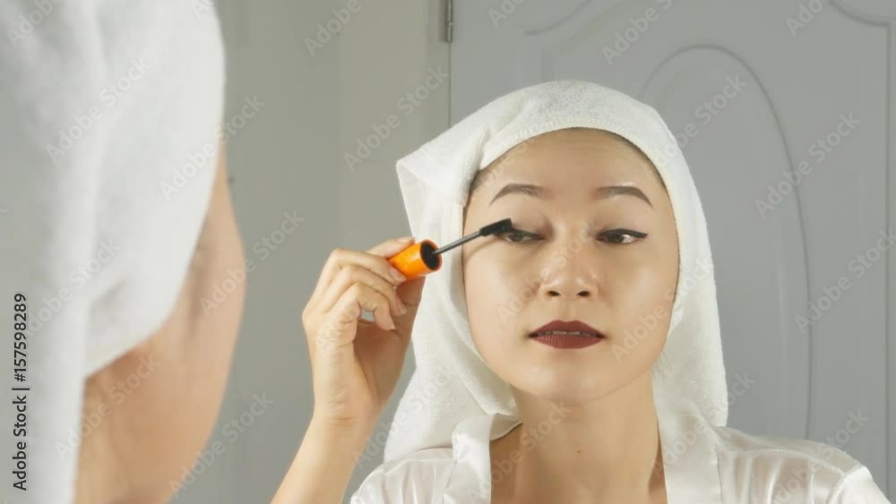 4k of Beautiful woman looking into the mirror and applying mascara make-up 4k of Beautiful woman looking into the mirror and applying mascara make-up