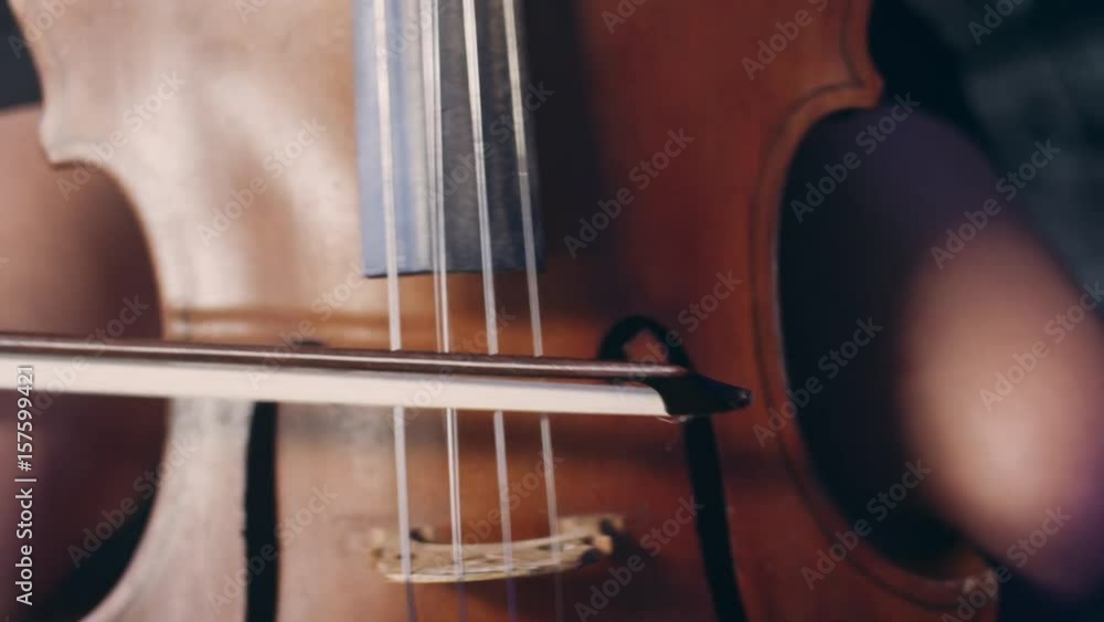 Woman hand playing violoncello with cello bow. Close up of female hand playing cello with cello bow. Cello playing music background. Female musician playing violoncello Woman hand playing violoncello with cello bow. Close up of female hand playing cello with cello bow. Cello playing music background. Female musician playing violoncello