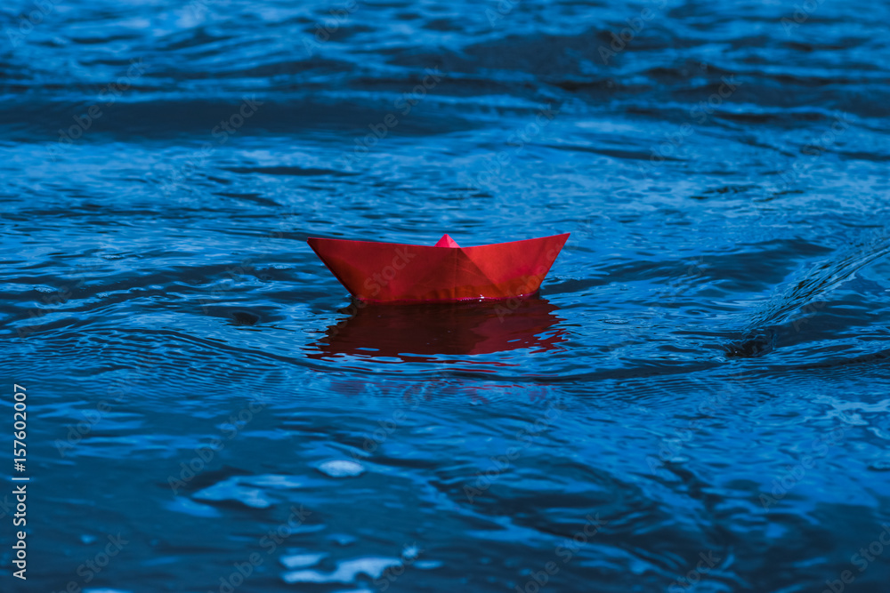 Fototapeta premium Red paper boat in a stormy river