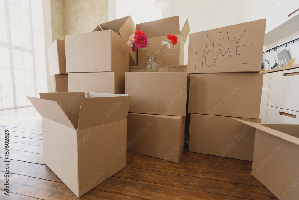 New home owners unpacking boxes, big cardboard boxes in new home. Moving to  a new apartment concept foto de Stock | Adobe Stock