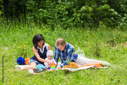 Happy Mixed Race Family Having a Picnic and Playing In The Park