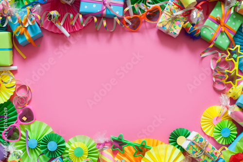 Gifts, garland, festive decor and confetti. Pink background.