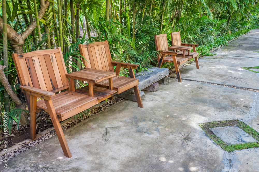 Natural wooden armchairs on pavement for relaxation. They are made of wood lumber.