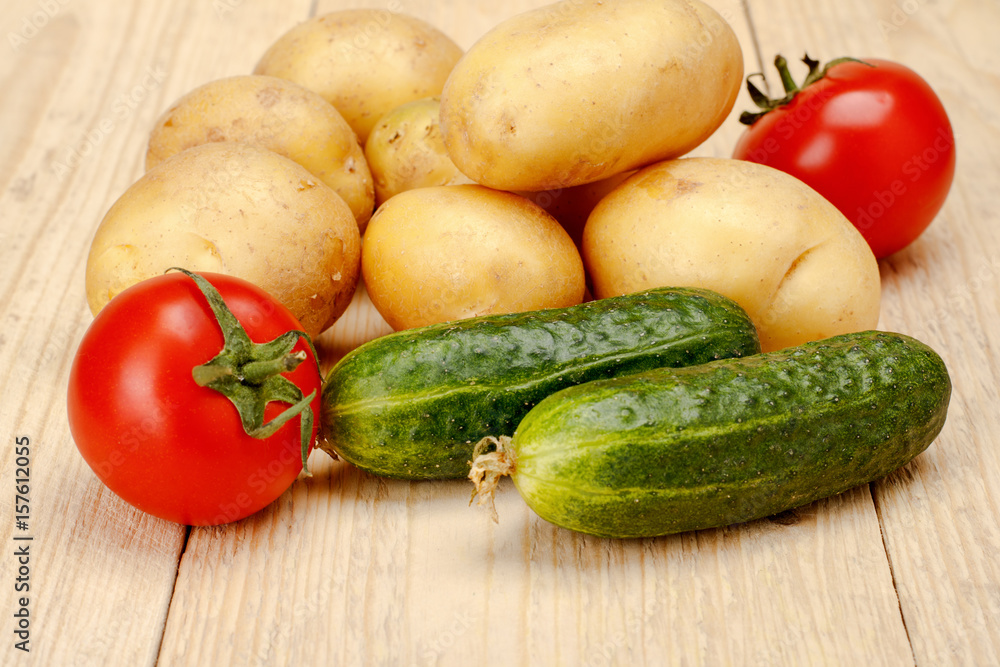 Tomatoes Cucumber potatoes on a white wooden background Tomatoes Cucumber potatoes on a white wooden background