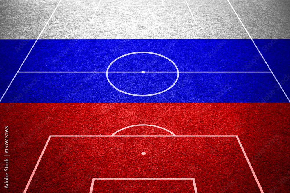 Empty soccer field with ground lines on sunny grass texture with painted Russia flag background. Goal side perspective used.