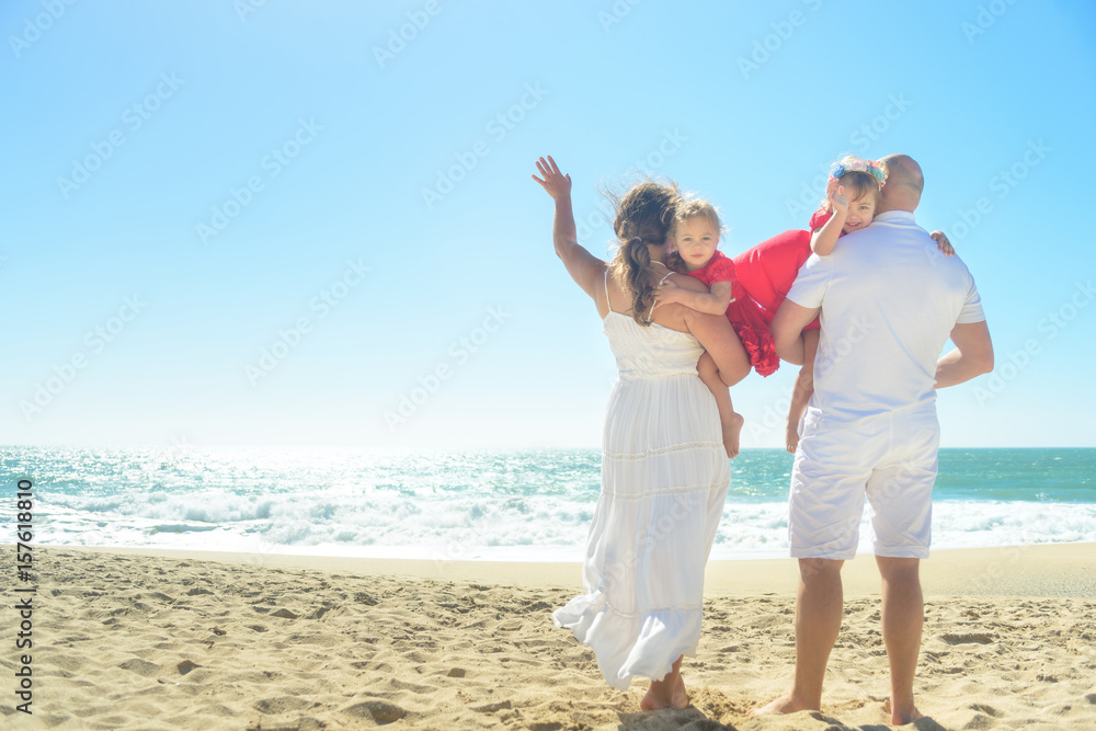 Happy family waving on the beach Happy family waving on the beach