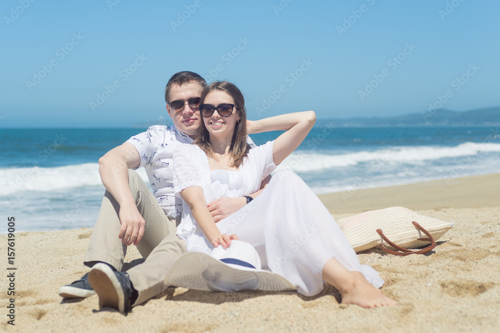 Young romantic couple sitting on the beach Young romantic couple sitting on the beach