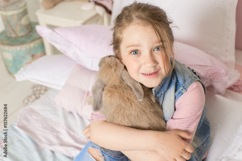 little girl hugging a rabbit. the way of life of the child. the concept of Pets