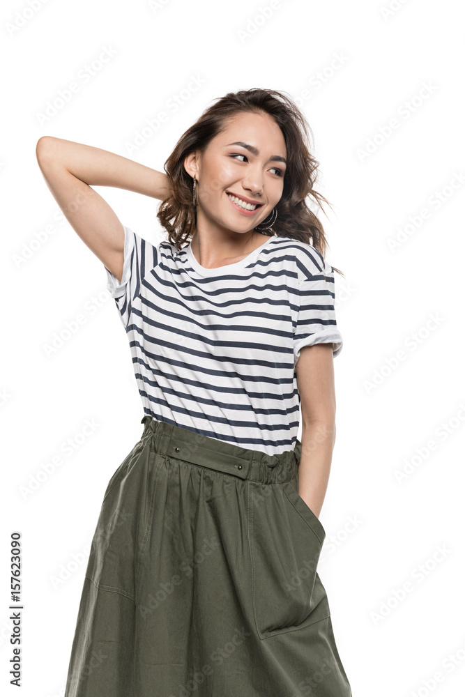 Smiling young woman with hand in pocket of skirt posing and looking away Smiling young woman with hand in pocket of skirt posing and looking away