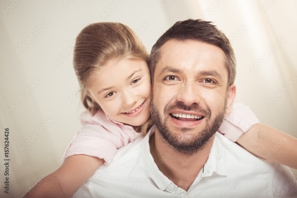 Close-up portrait of happy father and daughter hugging and smiling at camera Close-up portrait of happy father and daughter hugging and smiling at camera
