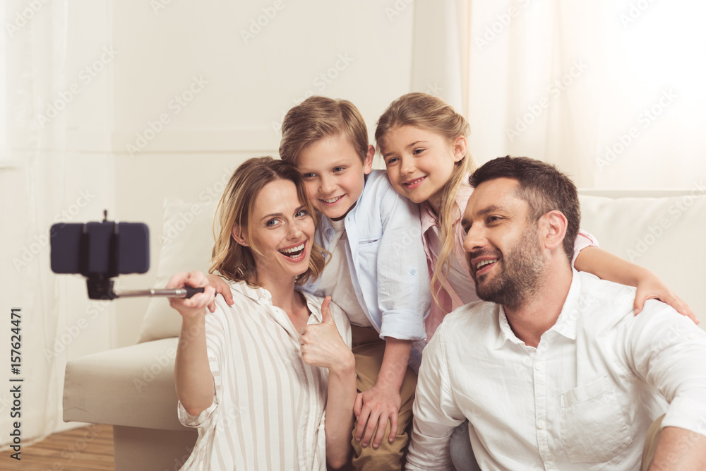 happy family taking selfie on smartphone with monopod at home happy family taking selfie on smartphone with monopod at home