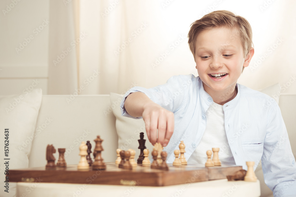 portrait of cheerful little boy playing chess alone at home portrait of cheerful little boy playing chess alone at home