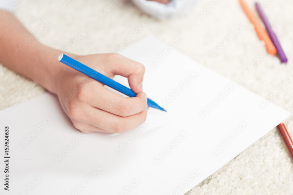 cropped shot of kid drawing with felt pen on blank paper sheet cropped shot of kid drawing with felt pen on blank paper sheet