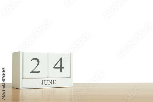 Closeup surface white wooden calendar with black 24 june word on blurred brown wood desk isolated on white background with copy space , selective focus at the calendar