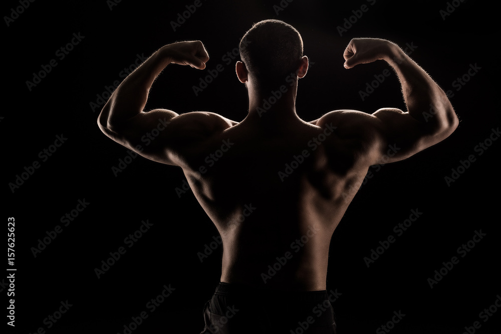 Fototapeta premium back view of young shirtless athlete flexing biceps