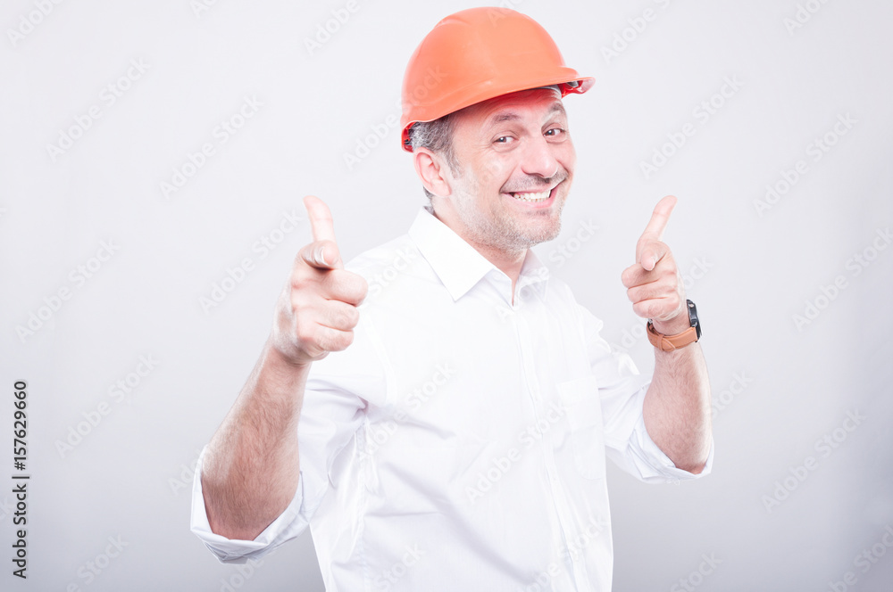 Portrait of contractor wearing hardhat pointing camera