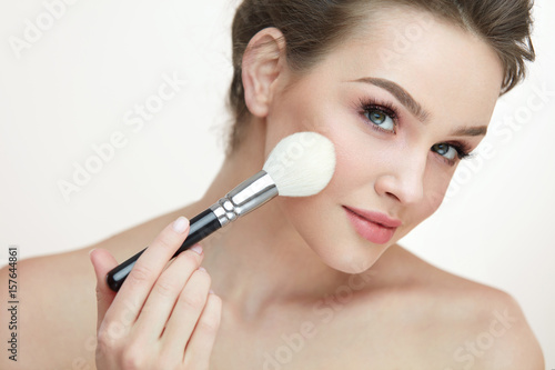 Face Makeup Cosmetics. Beautiful Female Applying Blush