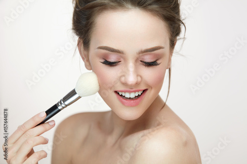 Facial Makeup. Beautiful Female Applying Blush With Brush