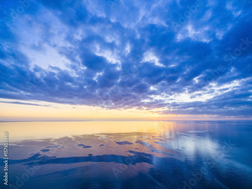 Sunset over ocean - blue cloudy sky, sun, and smooth water © Greg Brave
