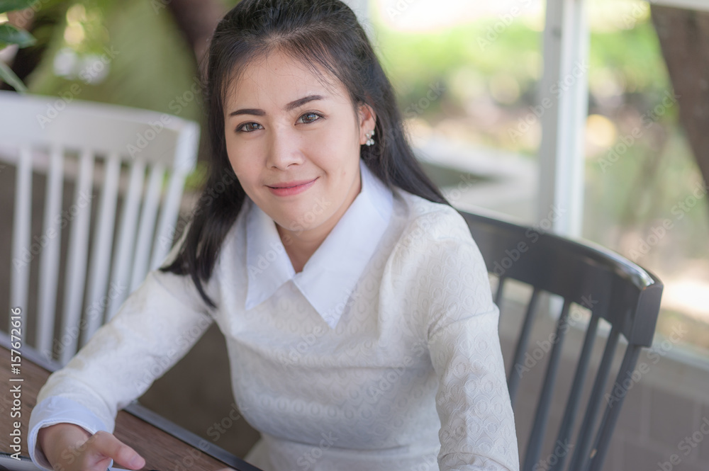 Young Asian woman smiling while sitting in cafe Young Asian woman smiling while sitting in cafe