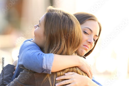 Hypocritical girl embracing a friend photo