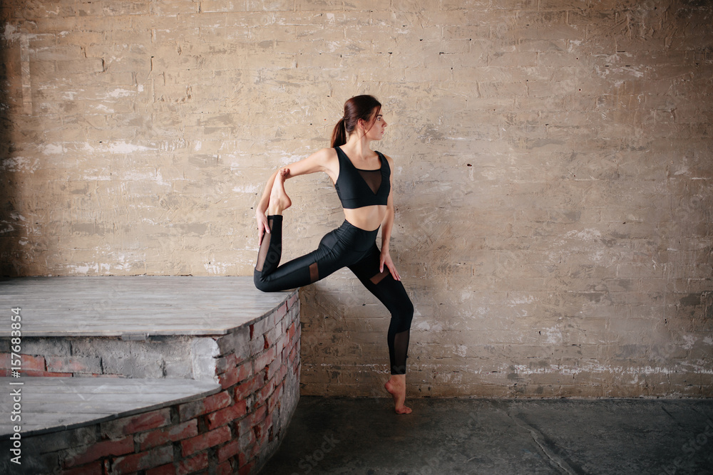 Fototapeta premium Young beautiful woman practicing yoga. Wellness concept. Tranquility and relaxation, happiness