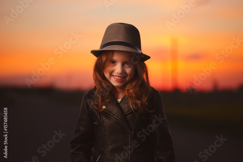 little girl with hat on evening sunset