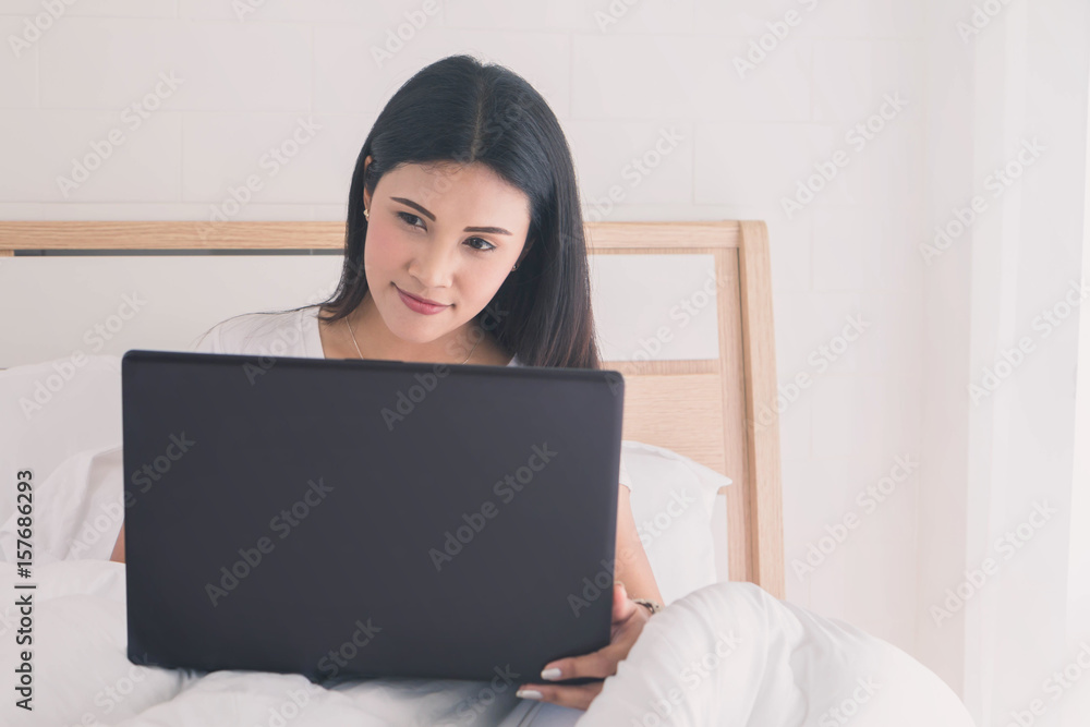 Young asian woman using laptop to working in bedroom. Young asian woman using laptop to working in bedroom.
