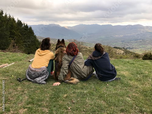 happy family mother, two daughters and dog pet looking panorama on the hills