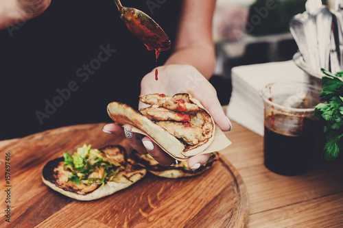 Street vendor hands making taco outdoors photo