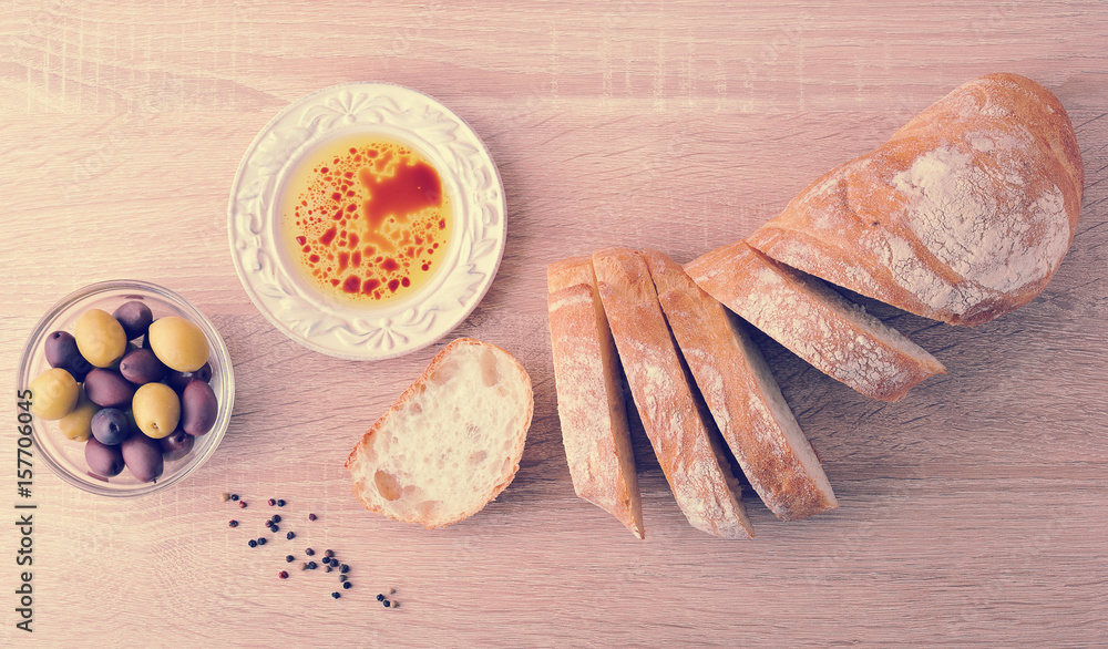 fresh bread, cut into slices with olives and olive oil with balsamic vinegar in a bowl fresh bread, cut into slices with olives and olive oil with balsamic vinegar in a bowl