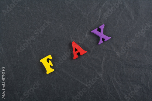 FAX word on black board background composed from colorful abc alphabet block wooden letters, copy space for ad text. Learning english concept.
