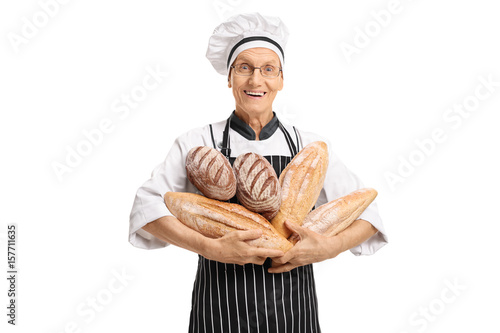 Tableau sur toile Elderly baker holding loaves of bread