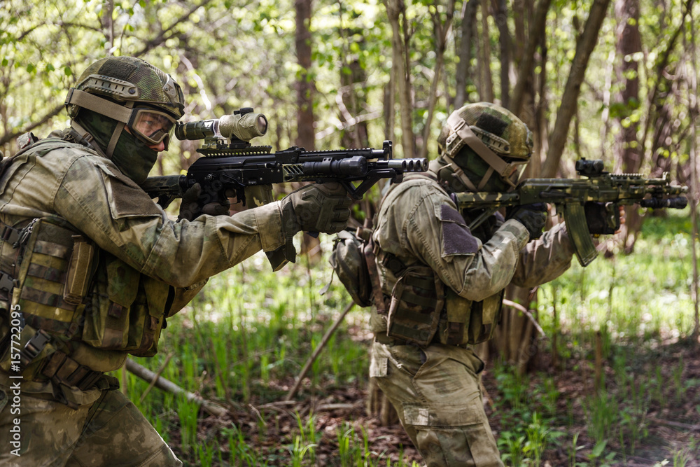 Two soldiers on assault in forest