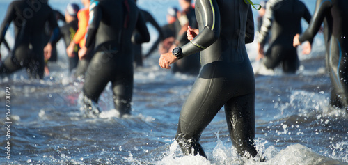 Fotografi Triathletes running out of the water on triathlon race