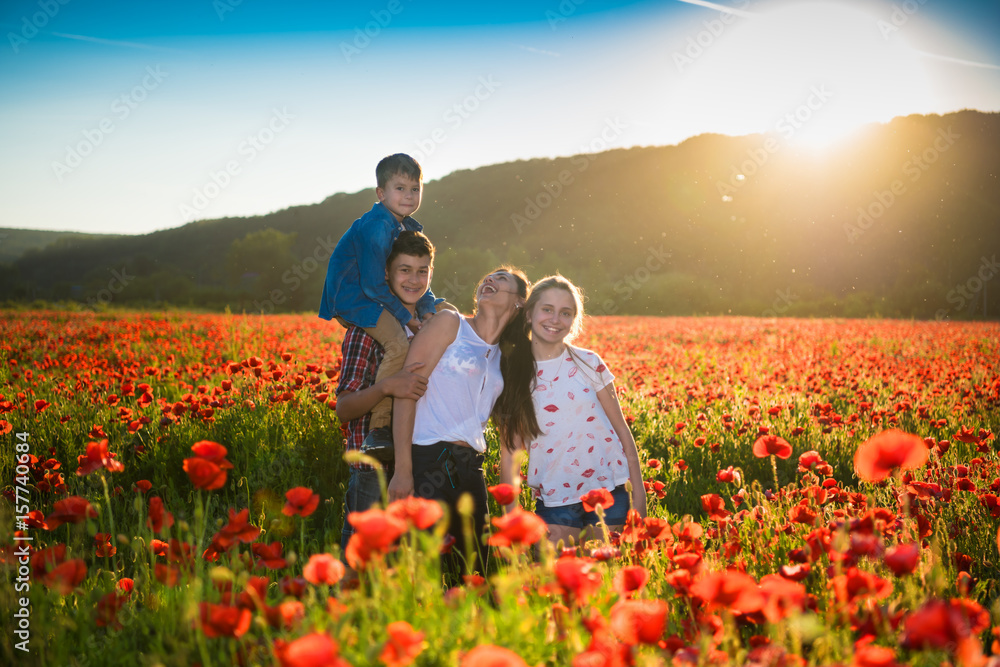 Happy family posing on the poppy field Happy family posing on the poppy field